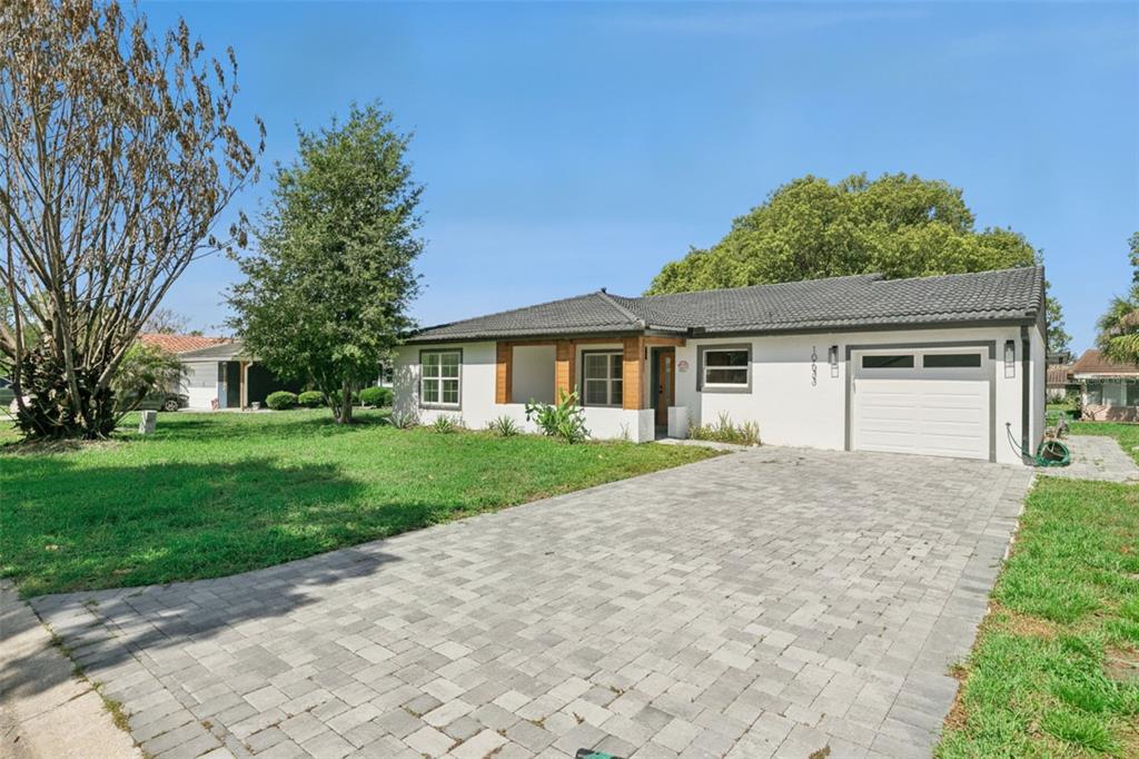 A single-story house with a white exterior, a tiled roof, and a paved driveway — 10633 WATERTOWN COURT, ORLANDO, FL