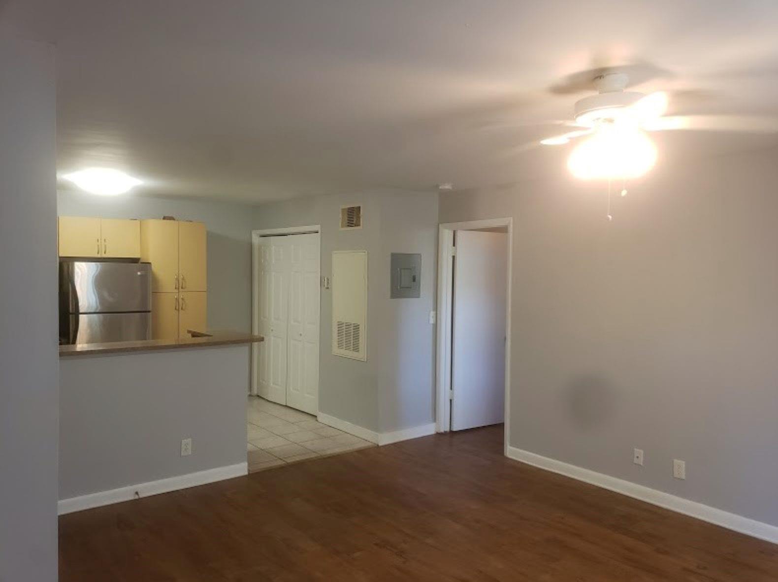 An open-concept living area with wood-look flooring, a ceiling fan, and a kitchen pass-through — 4096 N Pine Island Road # 2102, Sunrise FL 33351, SUNRISE, FL