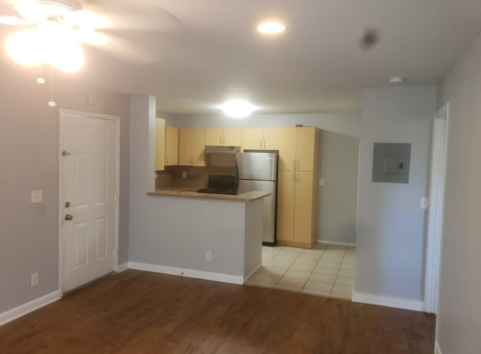 An open-concept kitchen with light wood cabinets and stainless steel appliances overlooks a living area — 4096 N Pine Island Road # 2102, Sunrise FL 33351, SUNRISE, FL