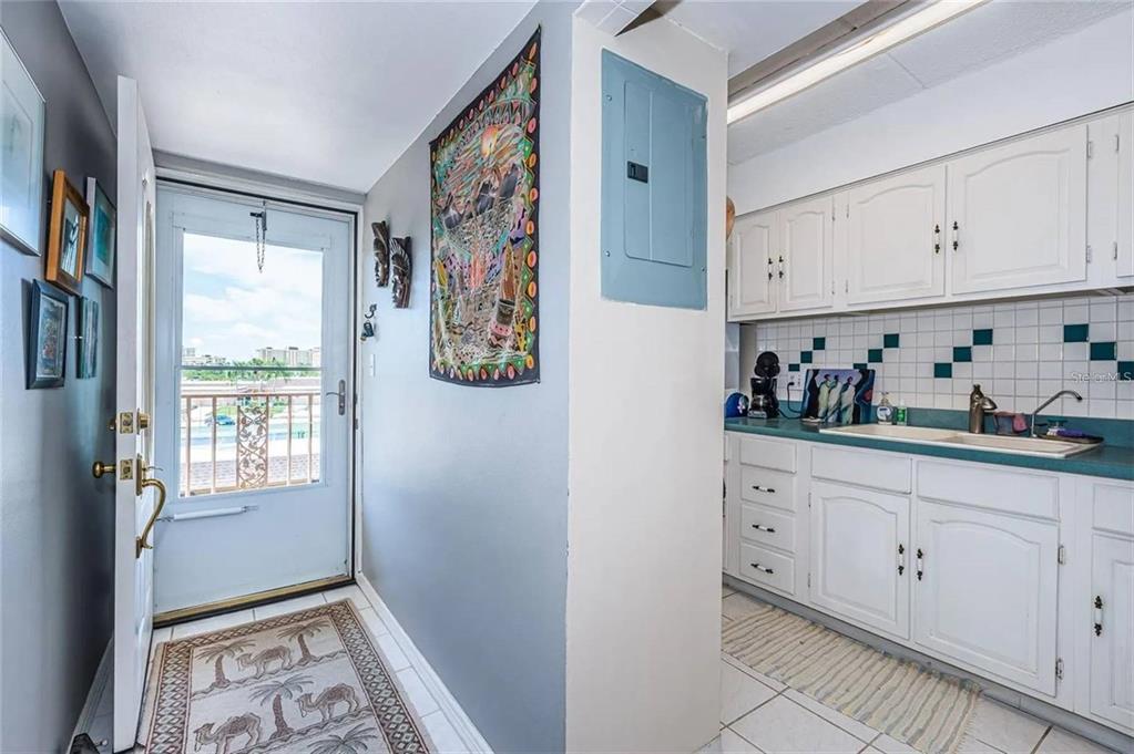 A kitchen with white cabinets and a blue countertop sits beside an entryway with tile — 1 BOCA CIEGA POINT BOULEVARD UNIT 314, ST PETERSBURG, FL