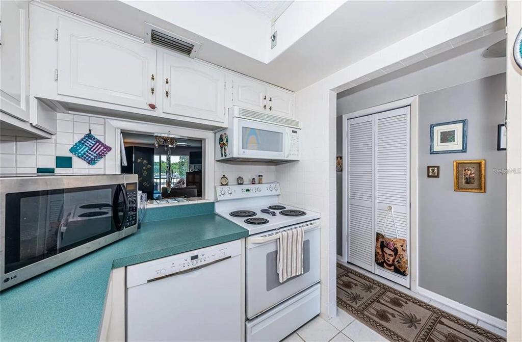 A kitchen features white cabinets, a green countertop, a white stove, and a microwave — 1 BOCA CIEGA POINT BOULEVARD UNIT 314, ST PETERSBURG, FL