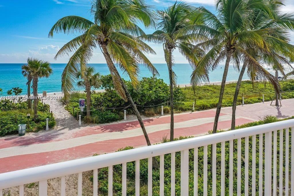 A balcony view overlooks a paved path, palm trees, and the ocean beach — 5401 Collins Ave # 410, Miami Beach FL 33140, MIAMI BEACH, FL