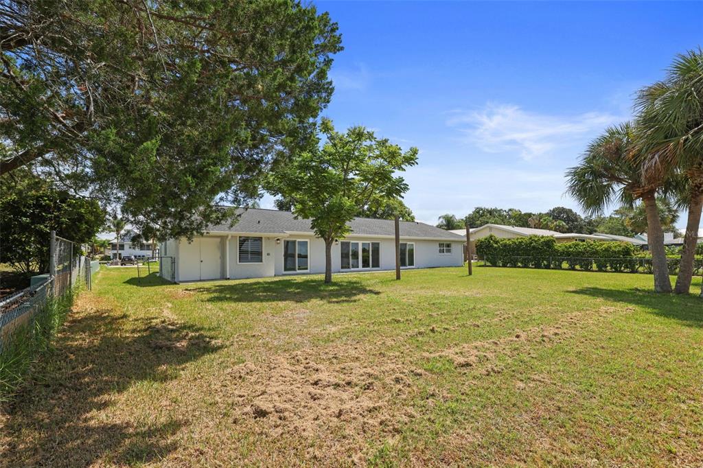 A view of the backyard and the rear exterior of a single-story house — 11930 W BAYSHORE DRIVE, CRYSTAL RIVER, FL