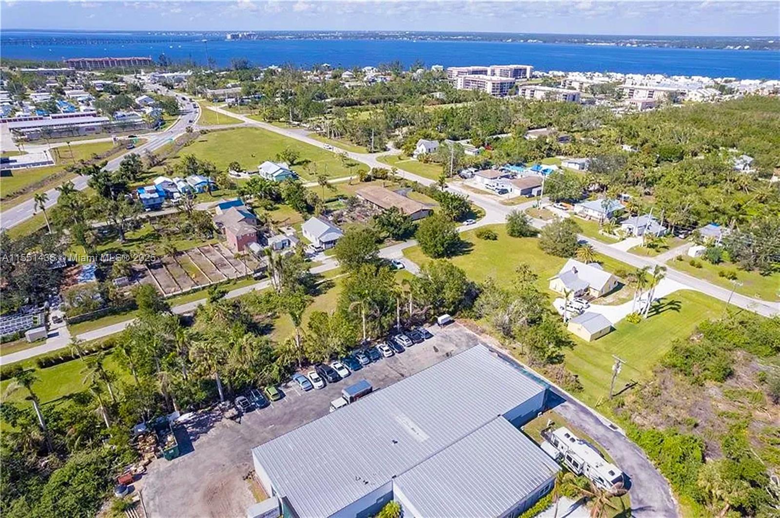 An aerial view shows a commercial building with a parking lot surrounded by residential properties — 514 SOLANA LOOP, Punta Gorda FL 33950, PUNTA GORDA, FL