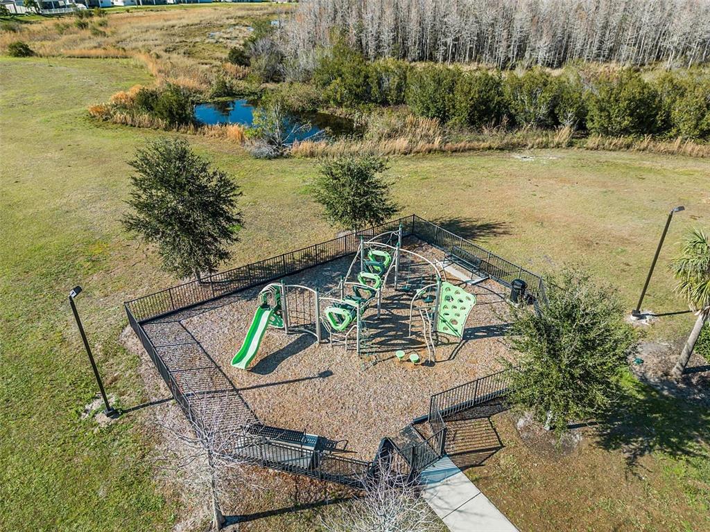 An aerial view of a fenced-in playground with climbing equipment and a slide — 3617 VEGA CREEK DRIVE, ST CLOUD, FL