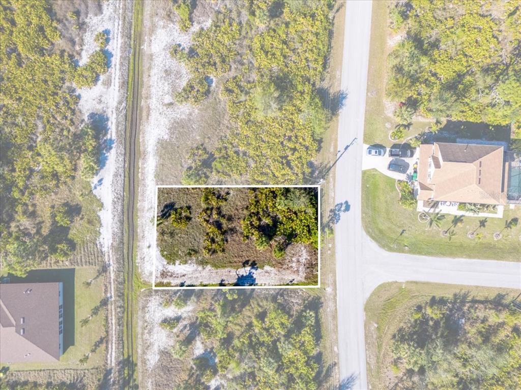 This aerial view shows a vacant, rectangular lot highlighted in white within a residential neighborhood — 9235 WALDREP STREET, PORT CHARLOTTE, FL