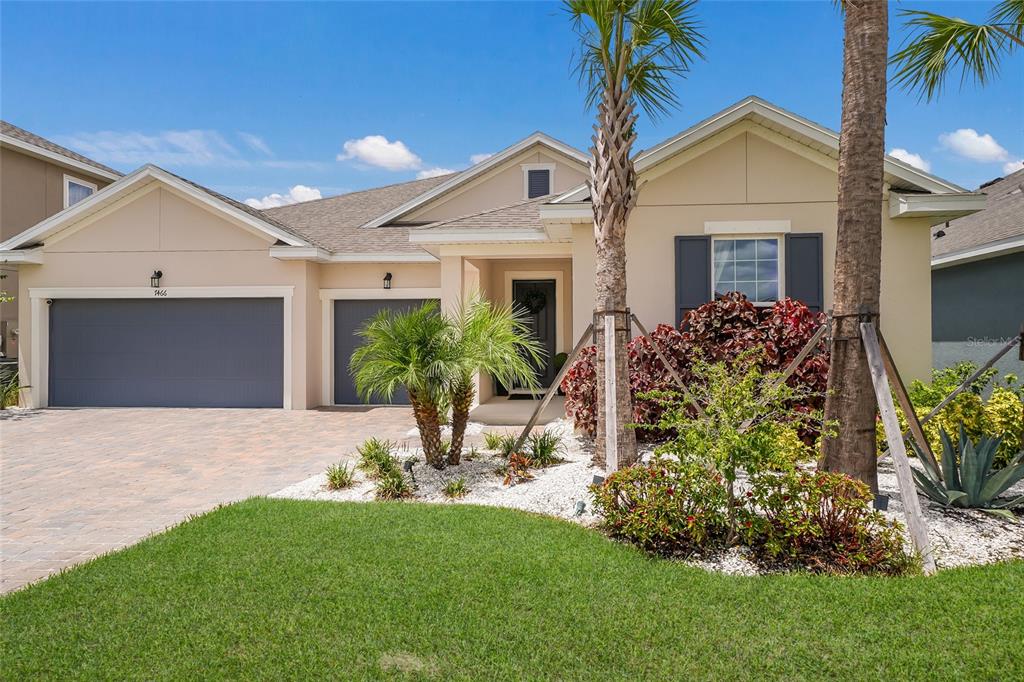 A covered patio overlooks a swimming pool with water features and a lake at sunset — 7466 SEA MANATEE STREET, PARRISH, FL