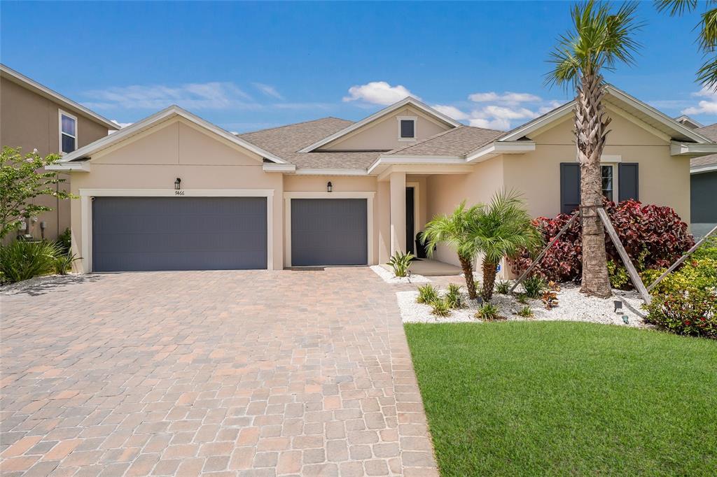 A paved driveway leads to a covered entryway with a dark front door and garage — 7466 SEA MANATEE STREET, PARRISH, FL