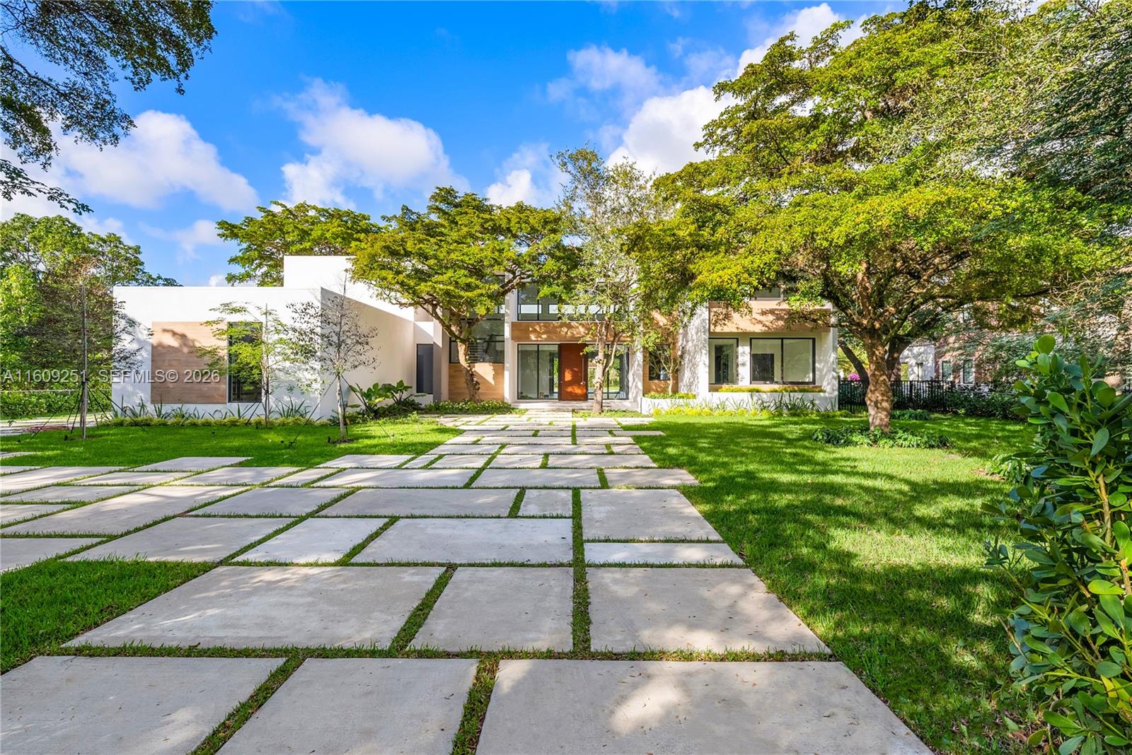 A modern two-story house features a concrete paver driveway and large trees in the yard — 6675 SW 96th St, Pinecrest FL 33156, PINECREST, FL