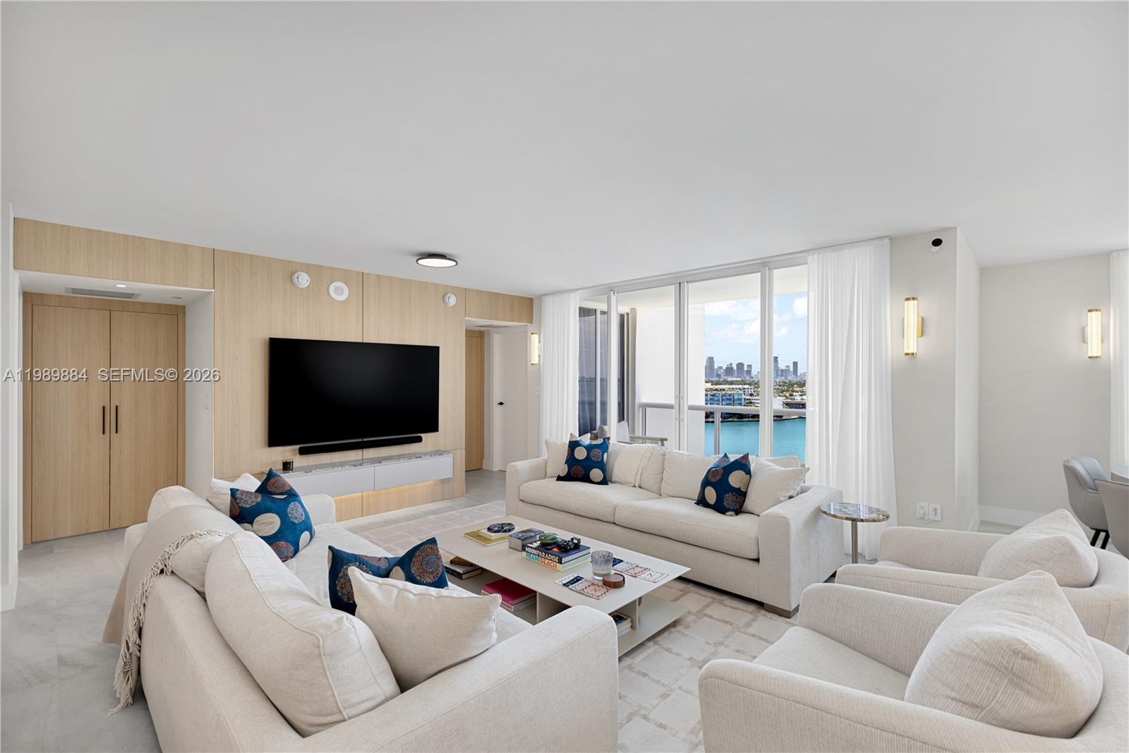 A living room features a light wood accent wall, white sofas, and a balcony view — 1800 Sunset Harbour Dr, Miami Beach FL 33139, MIAMI BEACH, FL