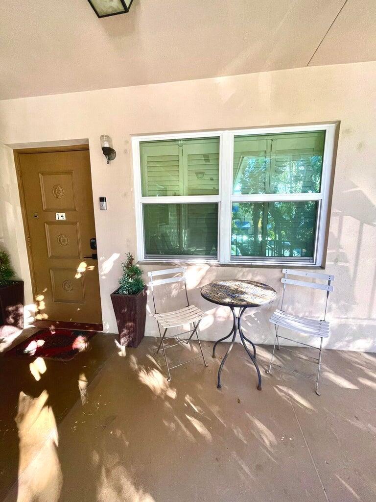 A patio features a brown door labeled 14, a window, and a small bistro set — 30 S J Street # 14, FL 33460, FL