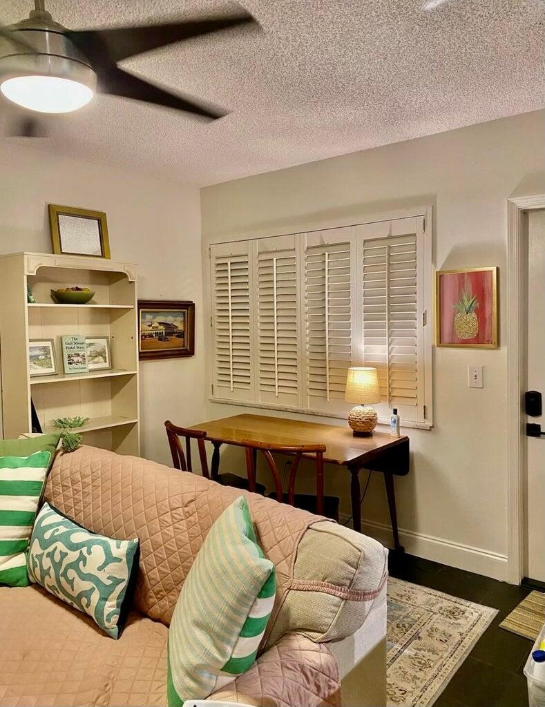 A living room features a sofa, a wooden desk with chairs, and white plantation shutters — 30 S J Street # 14, FL 33460, FL