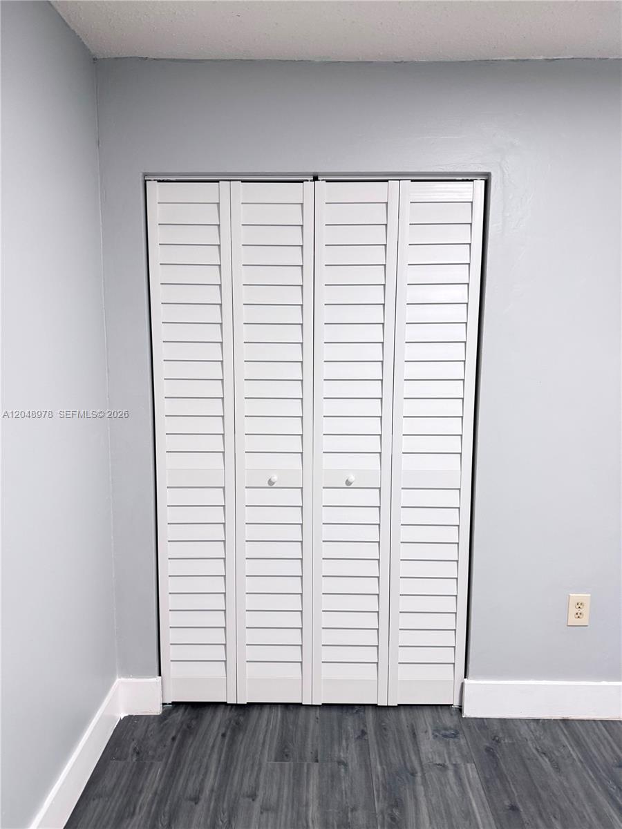 A white louvered bifold closet door is set against a light gray wall — 453 SW 2nd St # 306C, Miami FL 33130, MIAMI, FL