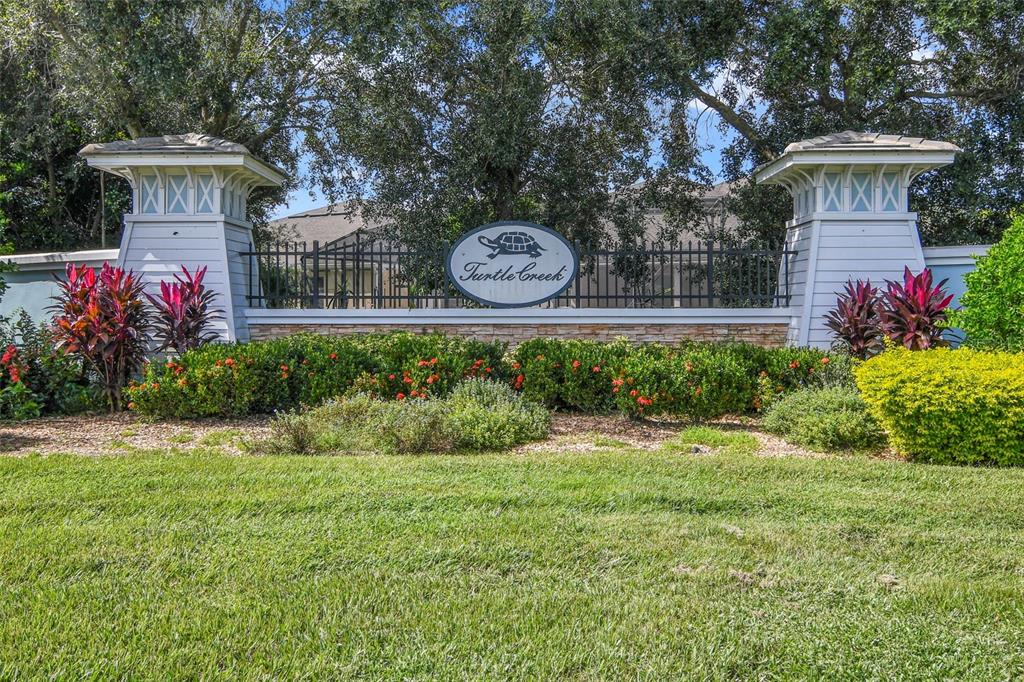 A stone and light-colored siding monument sign for Turtle Creek stands behind a landscaped lawn — 1529 ALLIGATOR STREET, ST CLOUD, FL