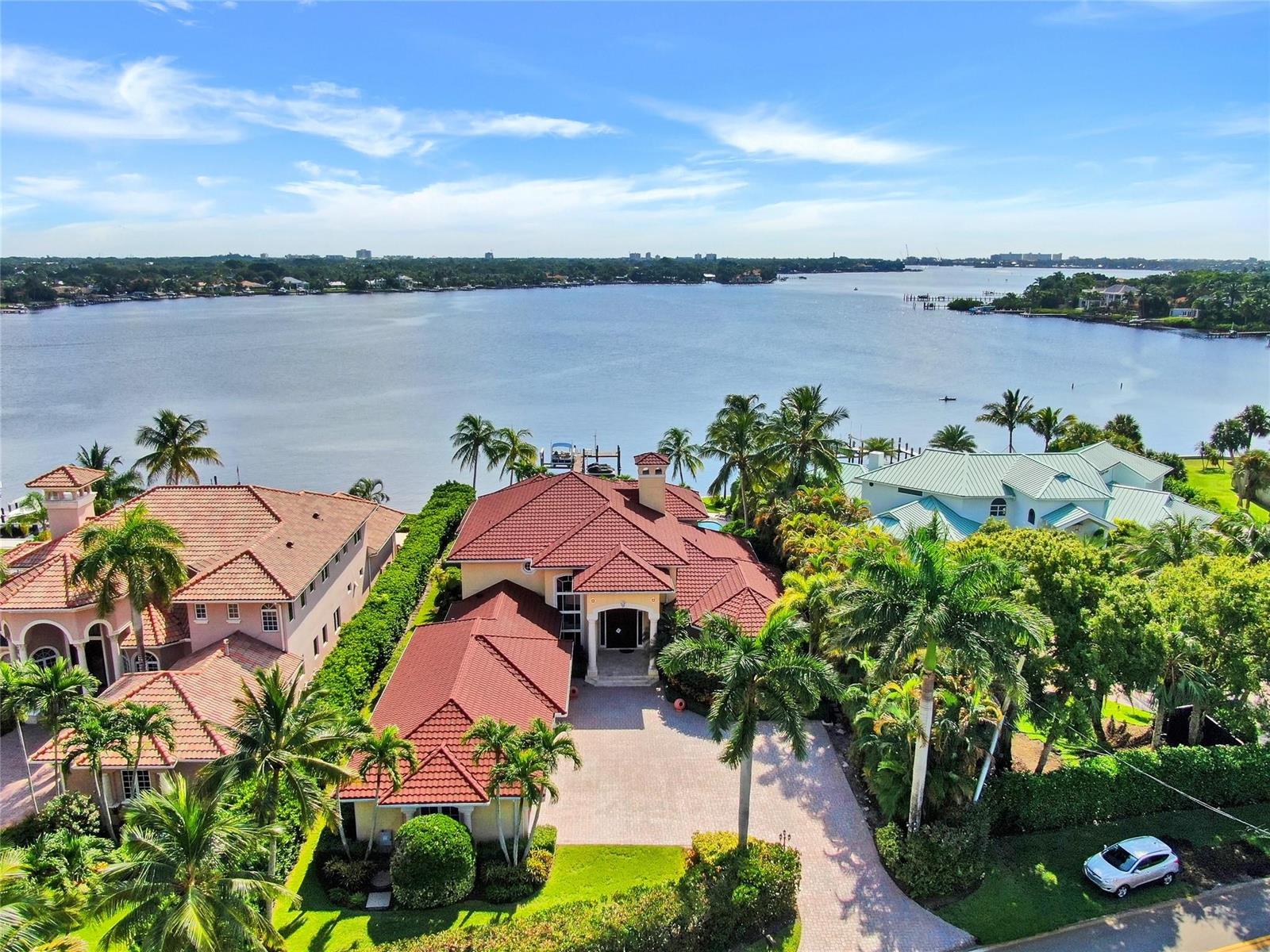 An aerial view of a waterfront house with a red tile roof and paved driveway — 19022 Loxahatchee River Road, Jupiter FL 33458, JUPITER, FL