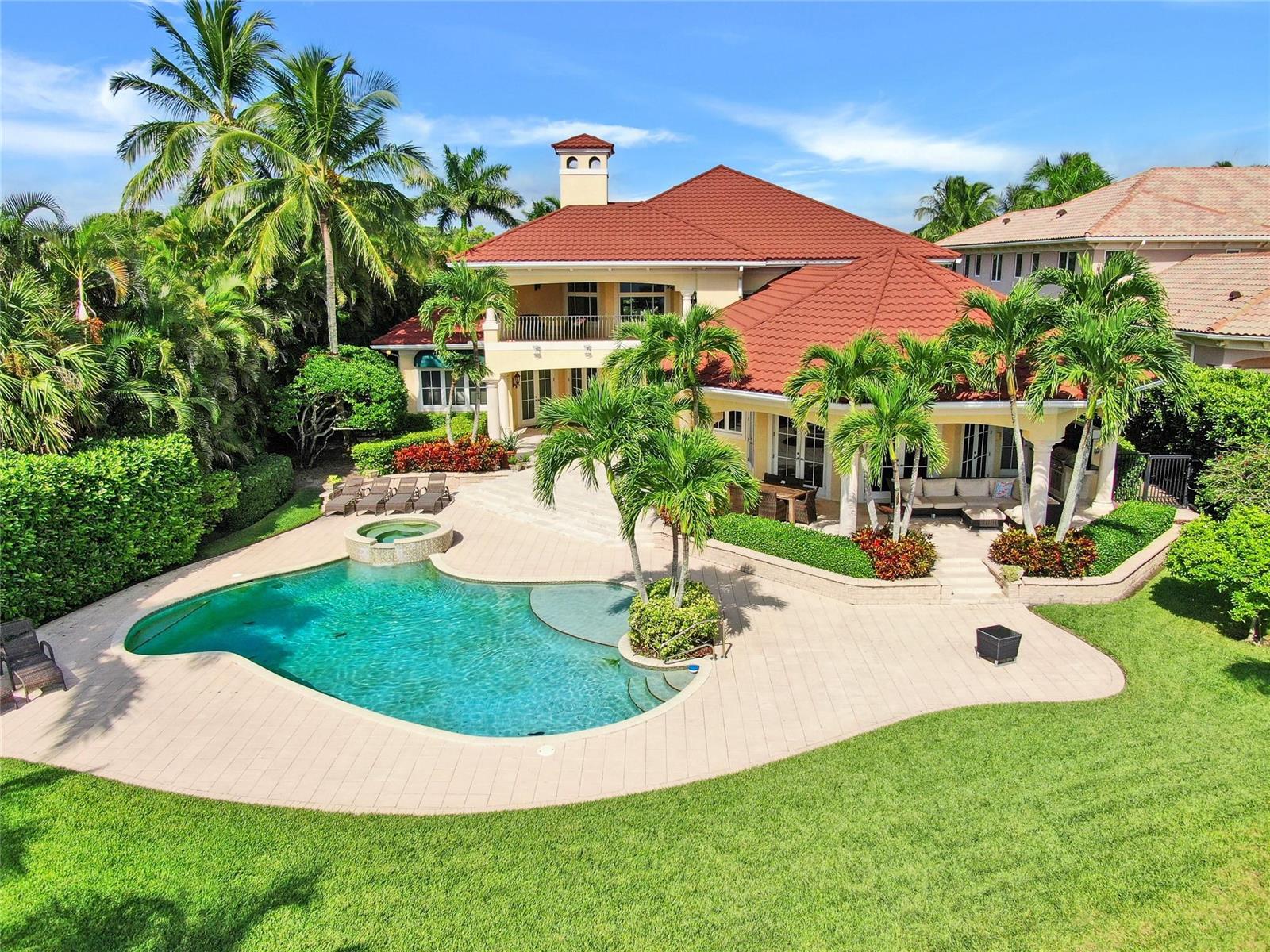 An aerial view of a two-story house with a red tile roof, pool, and landscaping — 19022 Loxahatchee River Road, Jupiter FL 33458, JUPITER, FL