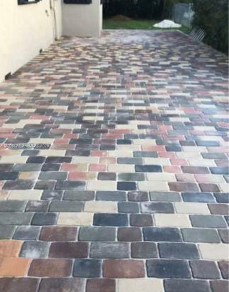 A patio area features a multi-colored brick paver surface extending from a building exterior — 1342 NW 42nd St, Miami FL 33142, MIAMI, FL