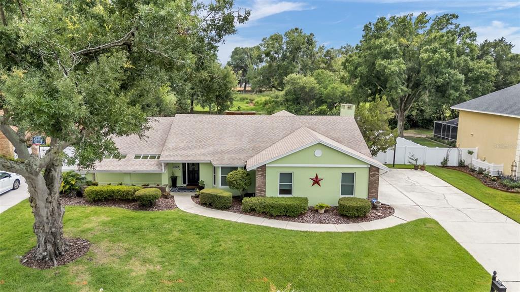 An aerial view of a light green, single-story house with a large tree and driveway — 4765 HIGHLANDS PLACE CIRCLE, LAKELAND, FL