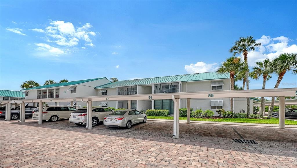 A two-story apartment building with a covered parking area and several parked cars — 5641 MIDNIGHT PASS ROAD UNIT 902, SARASOTA, FL