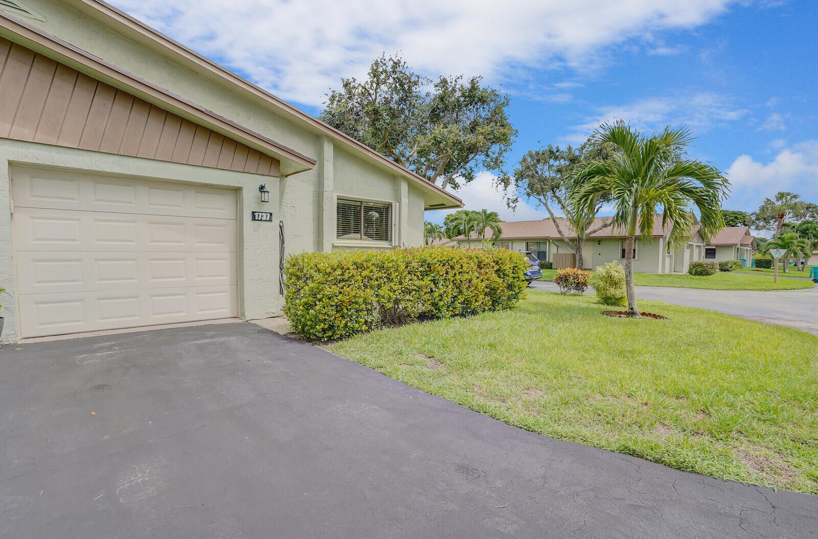A light green house with a garage, a driveway, and a small front lawn — 1737 Palmland Drive, Boynton Beach FL 33436, BOYNTON BEACH, FL