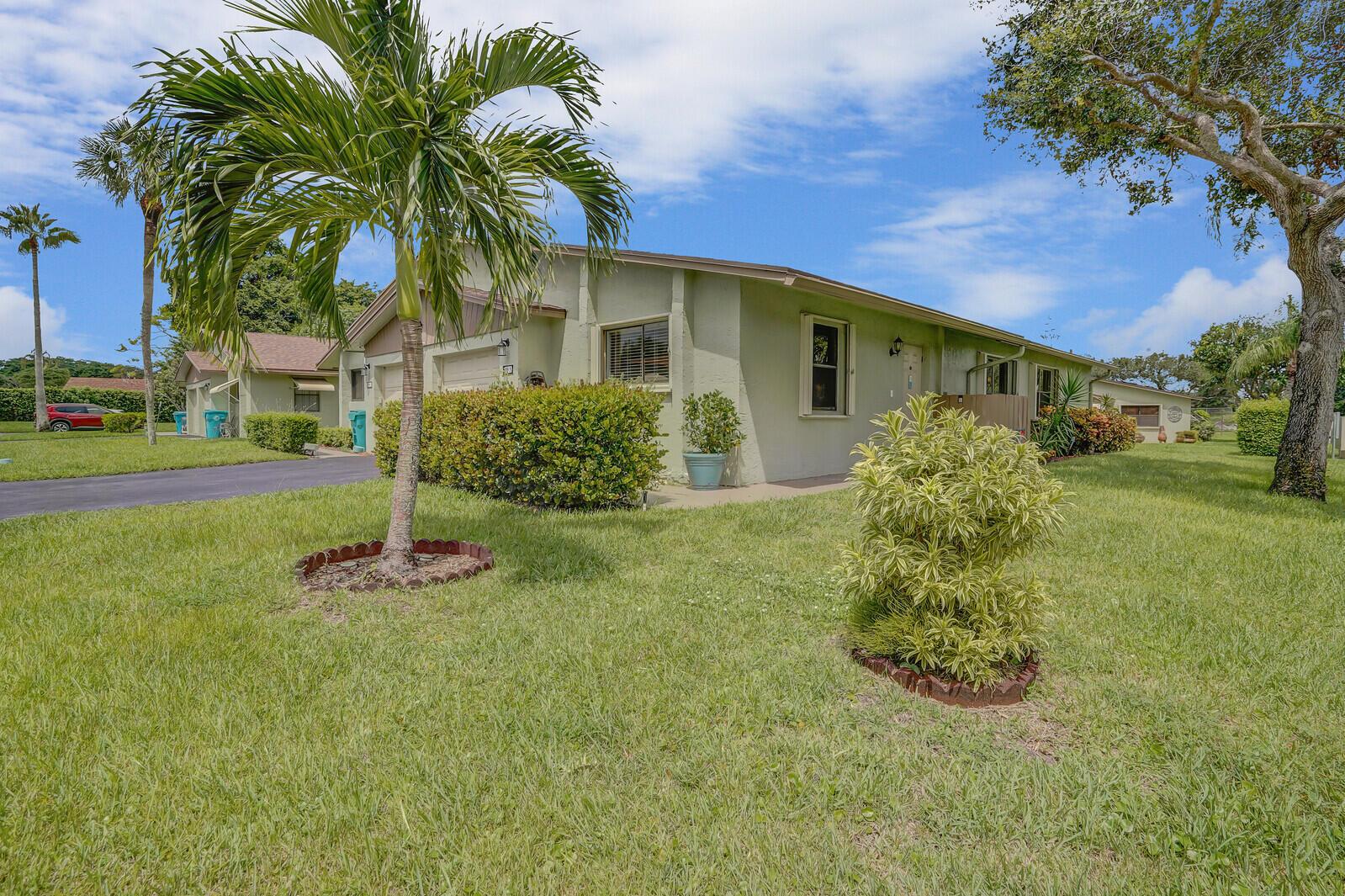 A light green single-story house with a palm tree and manicured lawn under a blue sky — 1737 Palmland Drive, Boynton Beach FL 33436, BOYNTON BEACH, FL