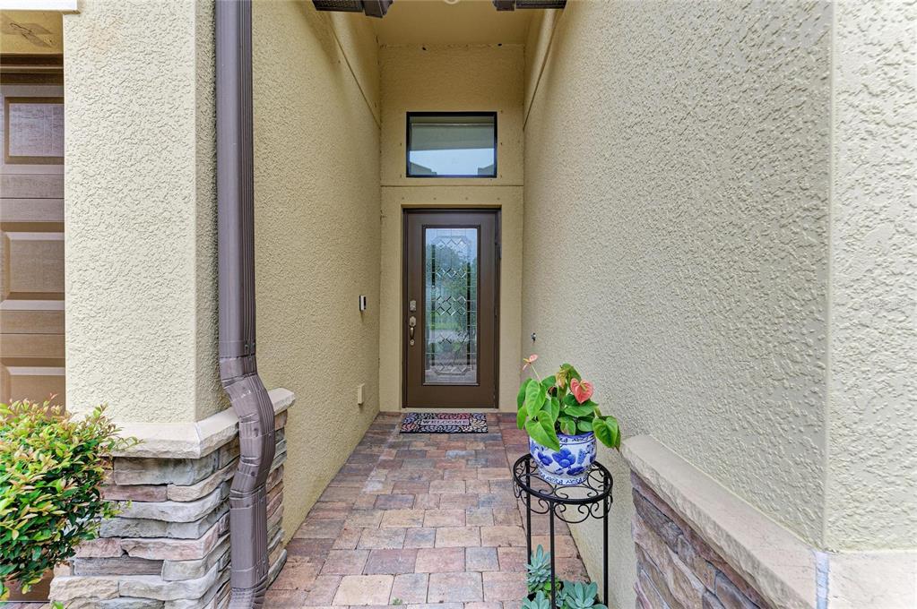 A front entryway features a brown door with a glass insert, a transom window, and pavers — 3512 SAVANNA PALMS COURT, BRADENTON, FL