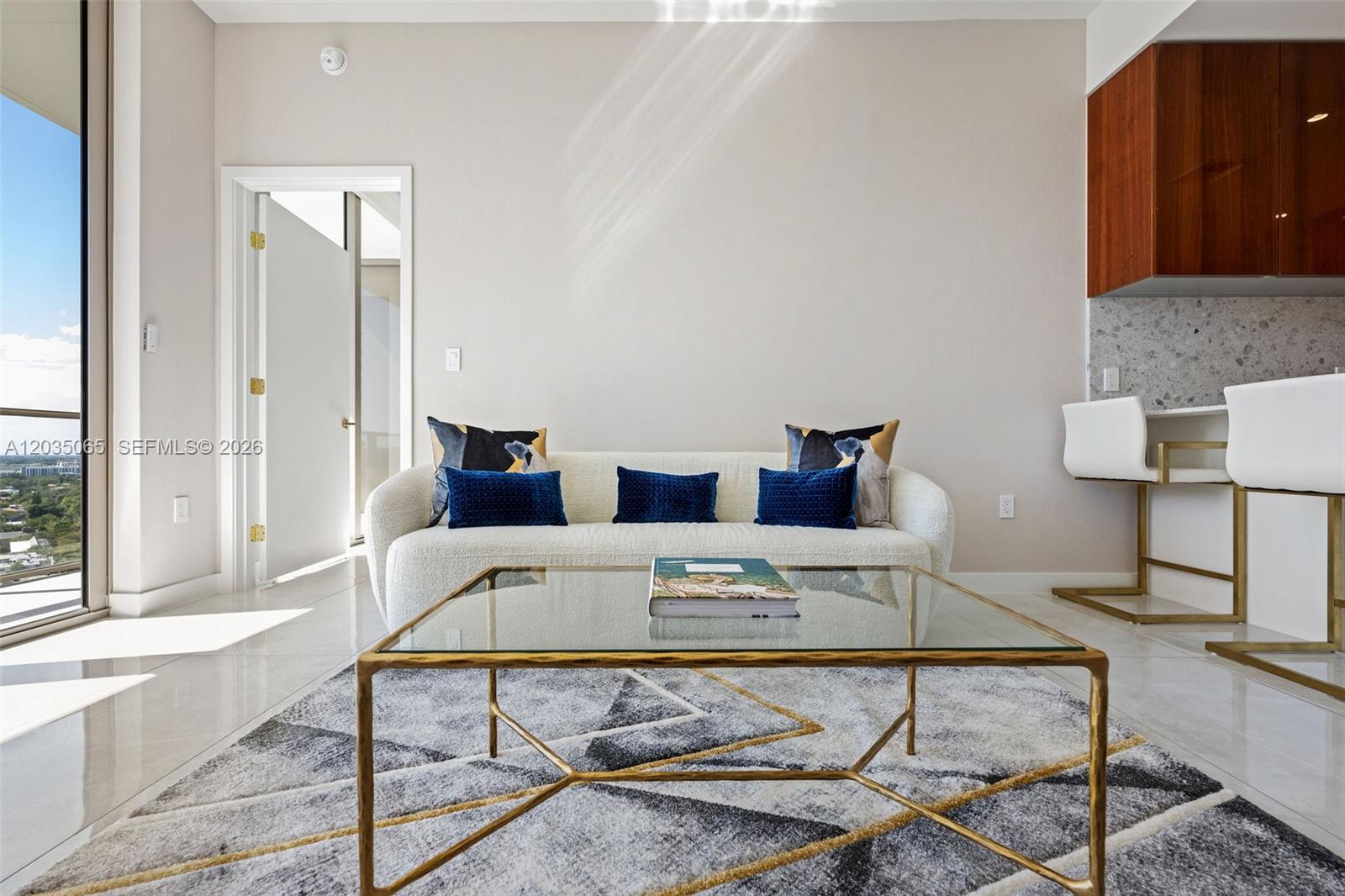 A modern living room features a white sofa, glass coffee table, and a patterned rug — 2678 Tigertail Ave # 1705, Miami FL 33133, MIAMI, FL