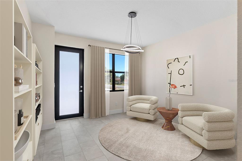 A modern sitting room features two cream armchairs, a round rug, and a glass door — 8405 MODANO PLACE, TAMPA, FL