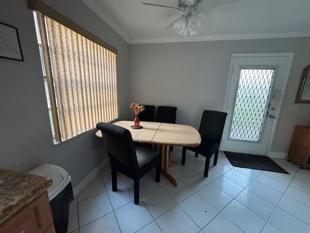 A dining area features a wooden table, black chairs, tile flooring, and a glass door — 107 Flanders, Delray Beach FL 33484, DELRAY BEACH, FL