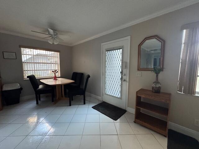 A dining area with a table, chairs, tile flooring, a ceiling fan, and an entryway door — 107 Flanders, Delray Beach FL 33484, DELRAY BEACH, FL
