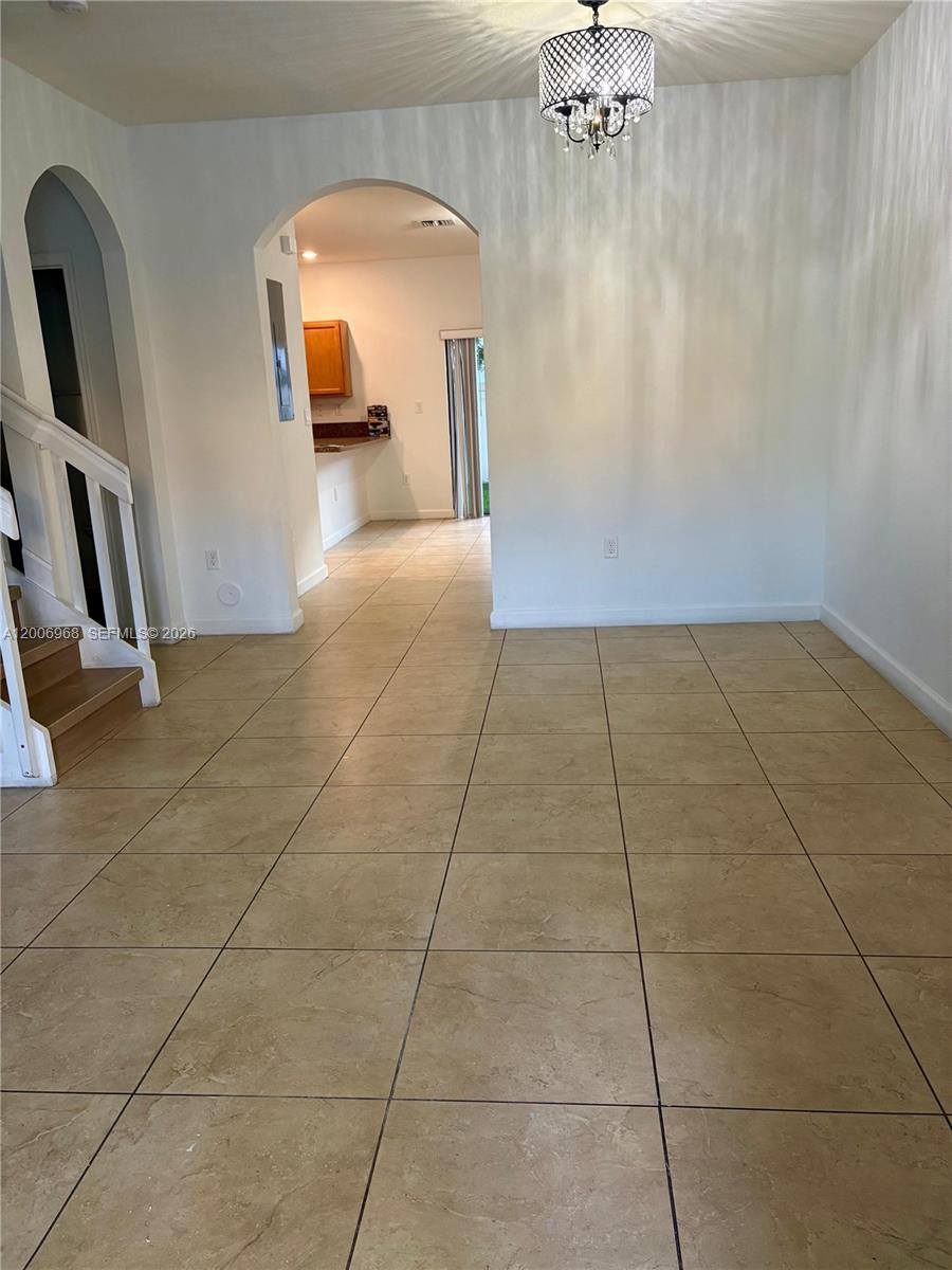This room features beige tile flooring, a decorative chandelier, and an arched entryway — 9228 W 33rd Way # 9828, Hialeah FL 33018, HIALEAH, FL