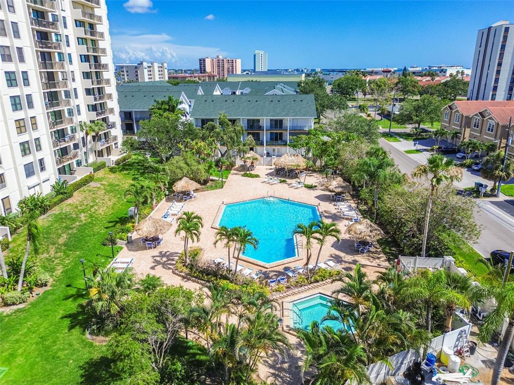 An aerial view of a swimming pool and hot tub surrounded by palm trees and buildings — 320 ISLAND WAY UNIT 304, CLEARWATER BEACH, FL