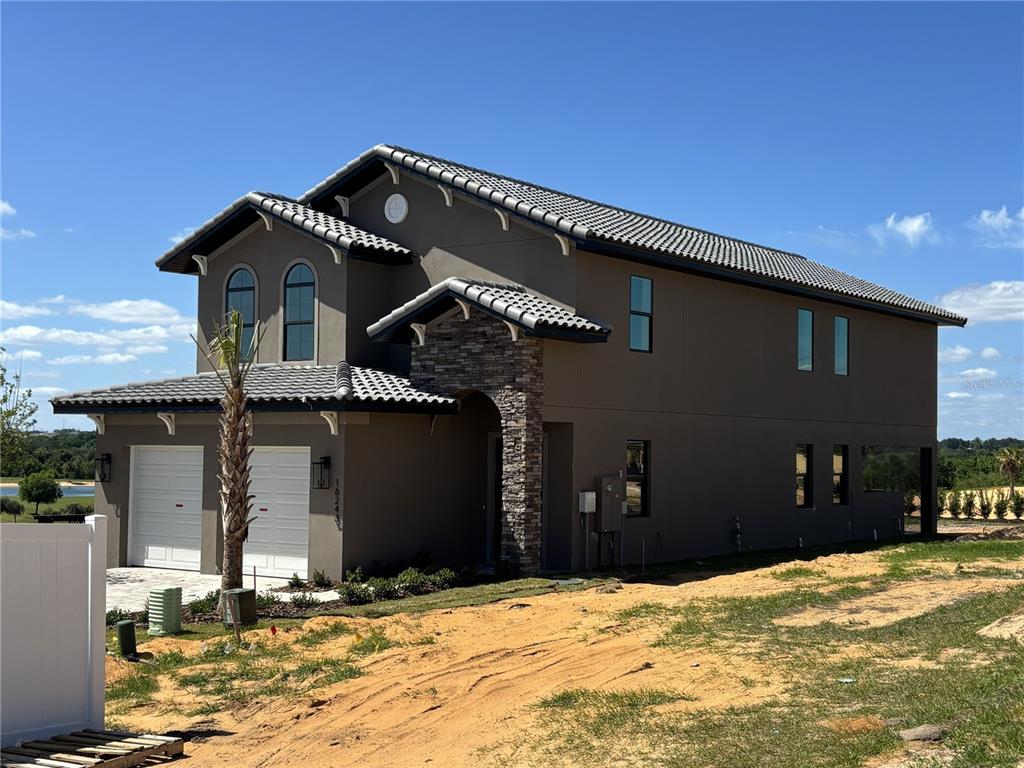 A two-story house with a tile roof, stone accents, and a two-car garage — 16243 VETTA DRIVE, MONTVERDE, FL