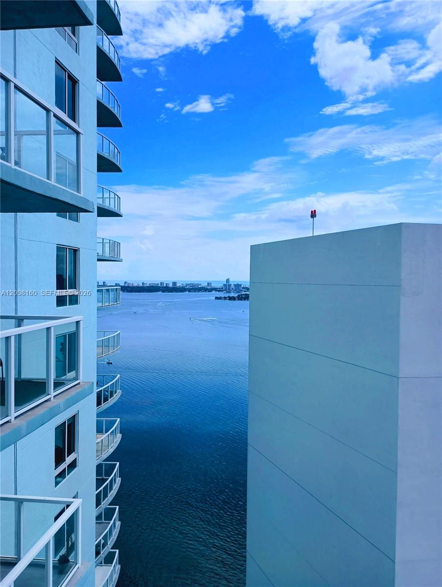 A view from a high-rise balcony overlooking a bay with a distant city skyline — 1900 N Bayshore Dr # 4007, Miami FL 33132, MIAMI, FL