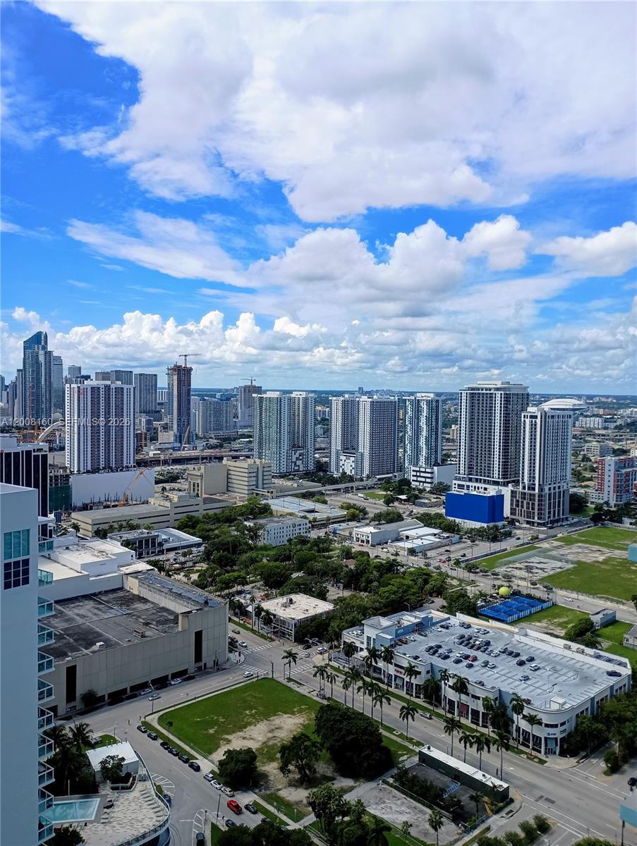 An elevated view of a city skyline featuring multiple high-rise buildings and urban streets — 1900 N Bayshore Dr # 4007, Miami FL 33132, MIAMI, FL