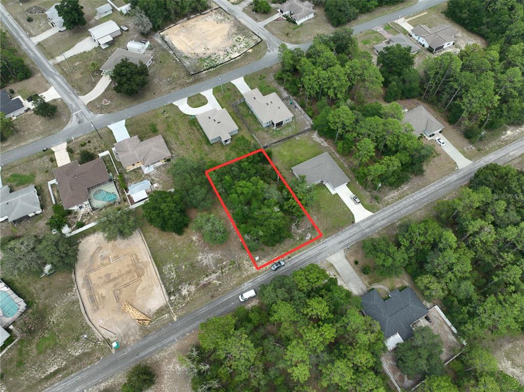 An aerial view shows a vacant, rectangular wooded lot outlined in red along a residential street — 9155 N HAMMOND WAY, CITRUS SPRINGS, FL