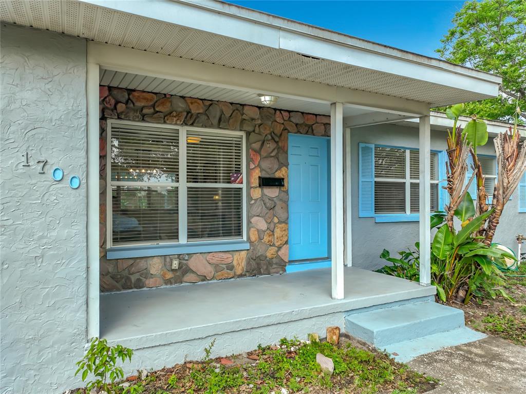 A single-story house exterior features a stone facade, a blue front door, and a porch — 1700 EDMUNDSHIRE ROAD, ORLANDO, FL