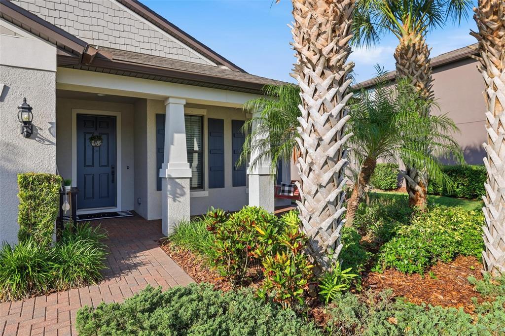 A front exterior view of a house with a brick walkway and palm trees — 2583 MARTON OAK BOULEVARD, NORTH PORT, FL