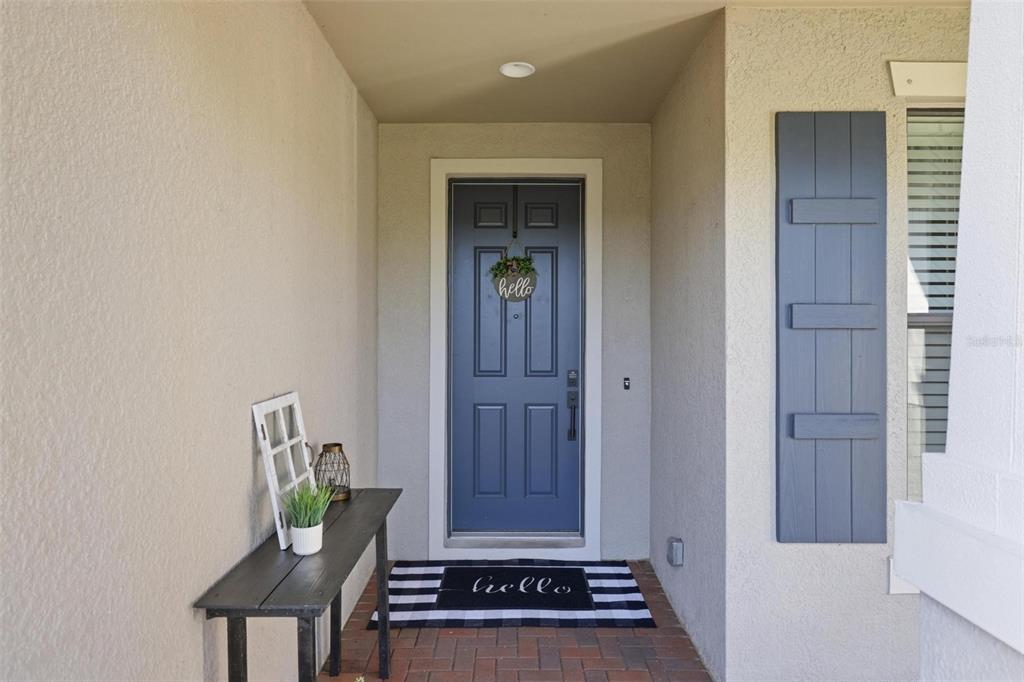 A front porch features a blue door, a black and white rug, and a small table — 2583 MARTON OAK BOULEVARD, NORTH PORT, FL