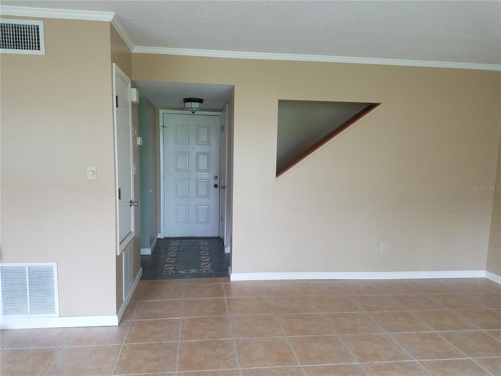An interior view shows a tiled room with a front door and a triangular wall cutout — 5421 VINELAND ROAD UNIT 6A, ORLANDO, FL