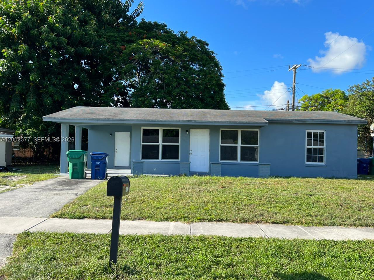 A single-story blue house with a covered porch, a front lawn, and a mailbox — 3461 NW 17th St, Lauderhill FL 33311, LAUDERHILL, FL