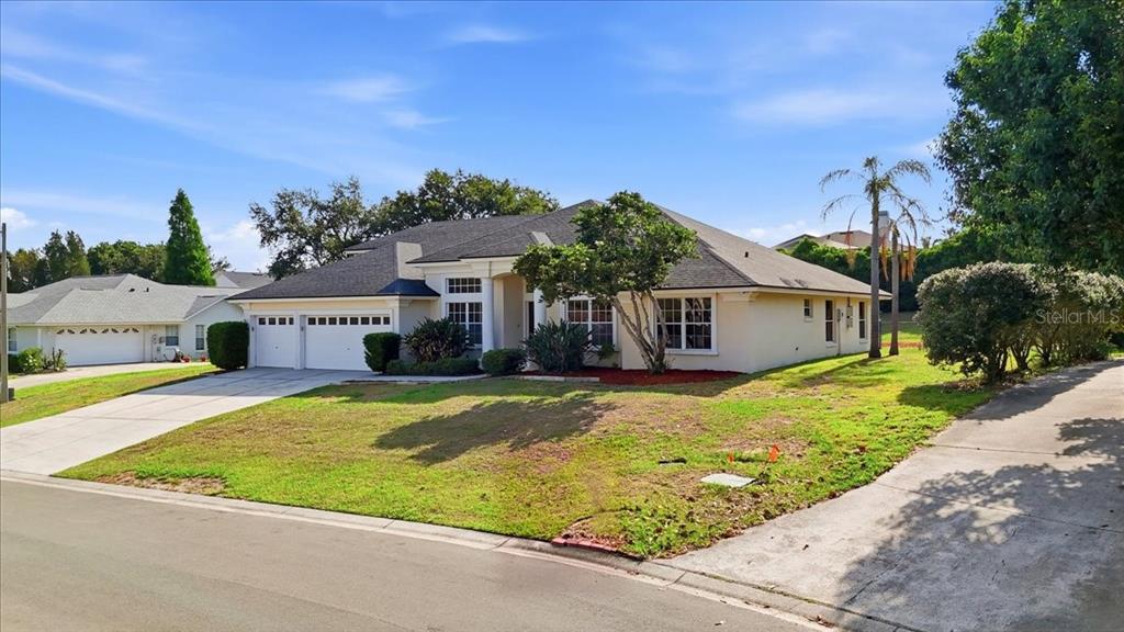 The front entrance of a house features a double door, white columns, and landscaping — 5628 WOODWIND HILLS DRIVE, LAKELAND, FL