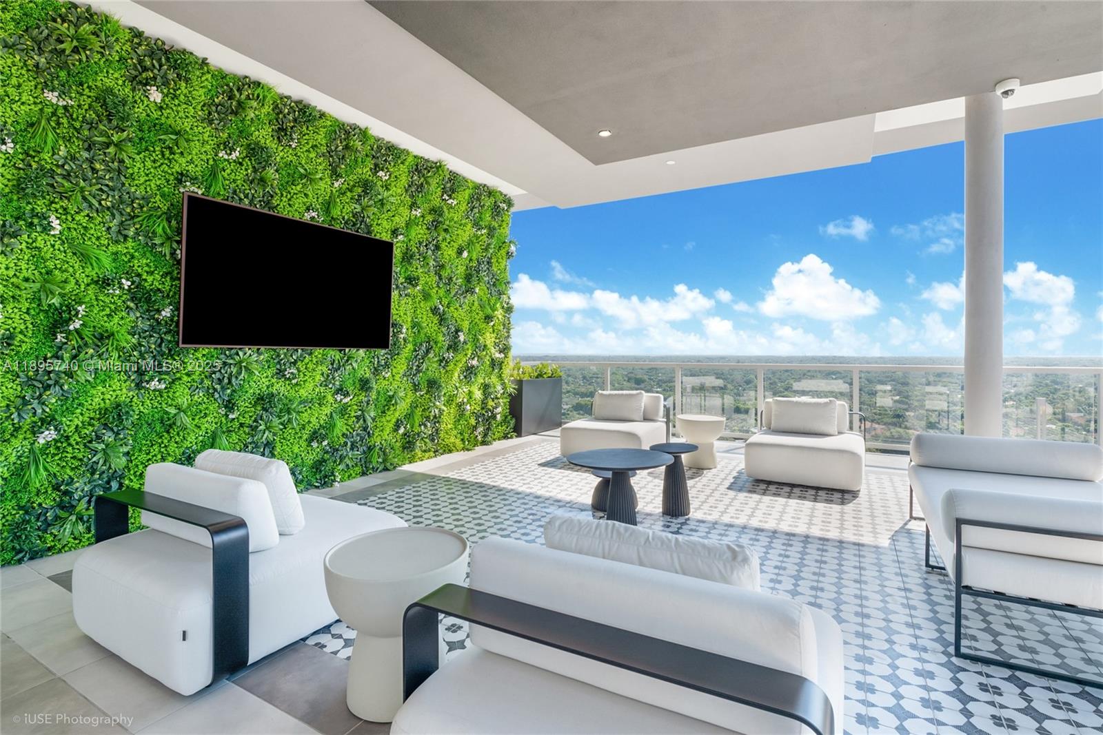 A modern outdoor balcony features white lounge furniture, a green wall, and a panoramic view — 9600 S Dixie Hwy # B10, Miami FL 33156, MIAMI, FL