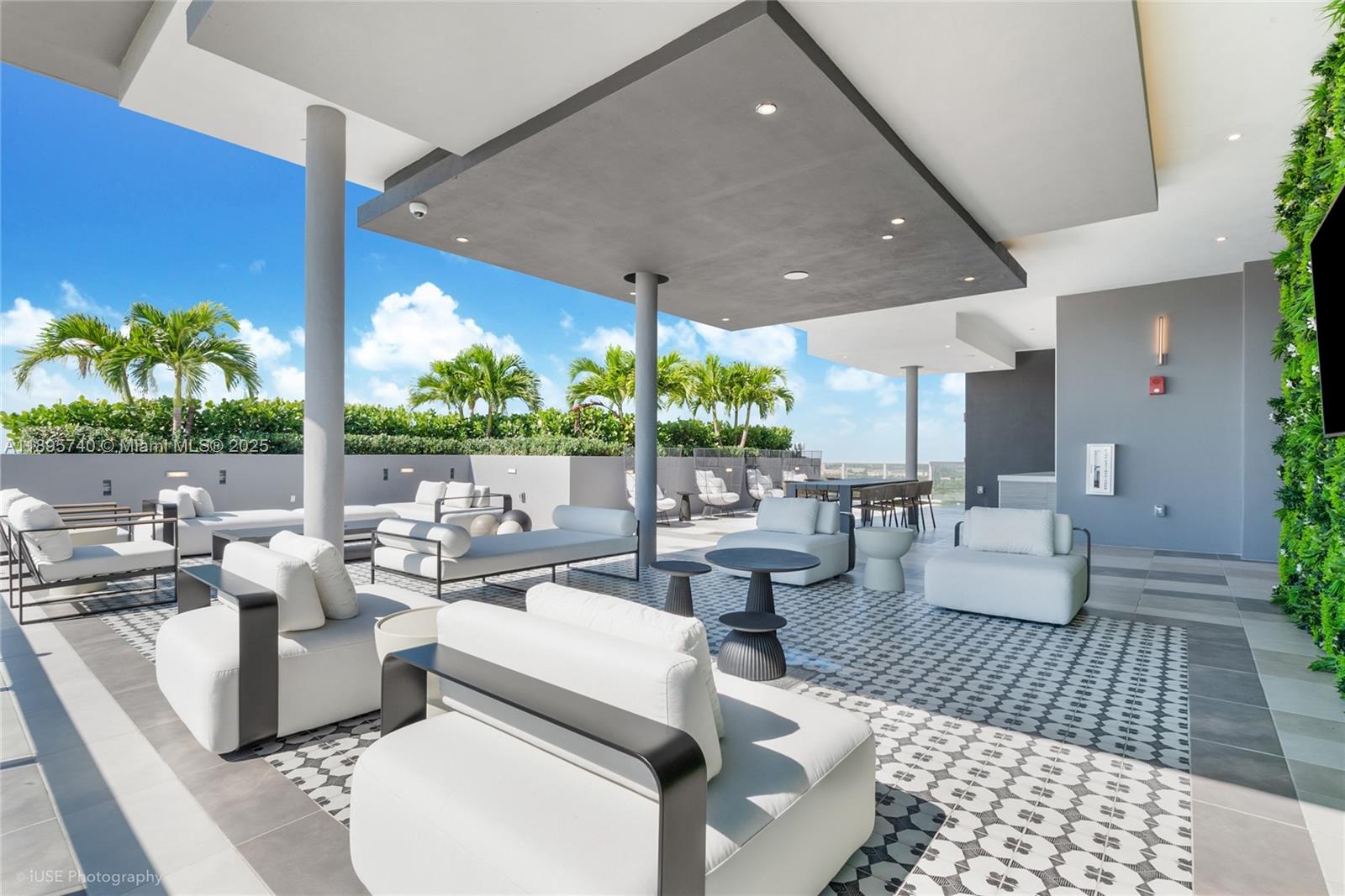 An outdoor rooftop terrace features modern white lounge furniture, patterned tile flooring, and palm trees — 9600 S Dixie Hwy # B10, Miami FL 33156, MIAMI, FL
