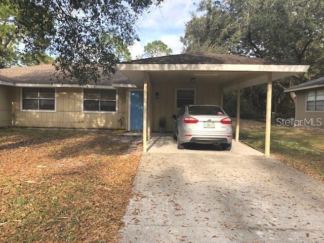 A single-story house with a carport and a silver car parked in the driveway — 232 BAMBOO DRIVE UNIT A, PORT CHARLOTTE, FL