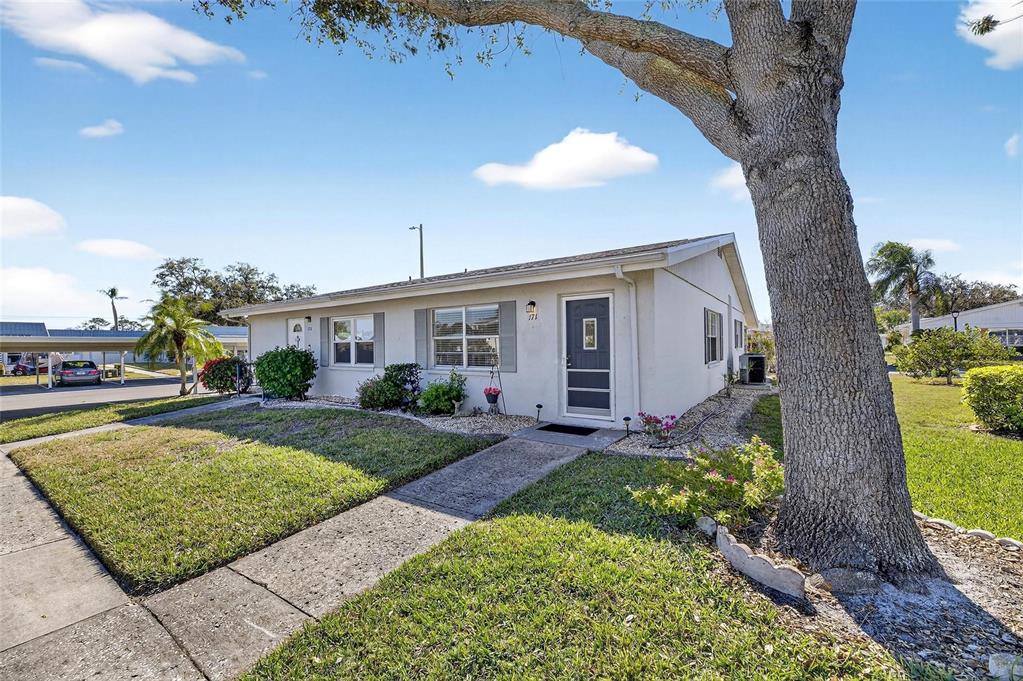 A single-story house with a light-colored exterior, a sidewalk, and a large tree — 301 ANDOVER PLACE S UNIT 171, SUN CITY CENTER, FL