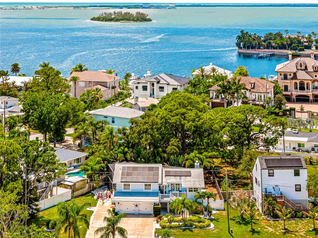 An aerial view shows a residential neighborhood with houses near a large body of water — 201 LAGOON DRIVE, PALM HARBOR, FL