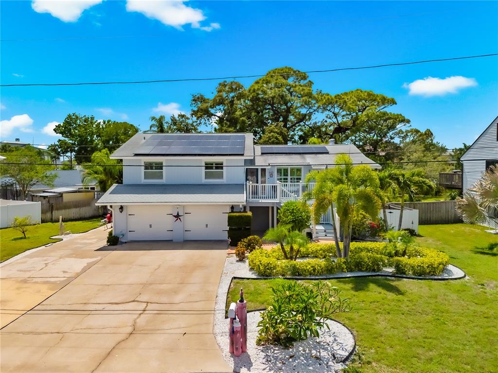 A two-story house with a two-car garage, a front deck, and palm trees in Florida — 201 LAGOON DRIVE, PALM HARBOR, FL