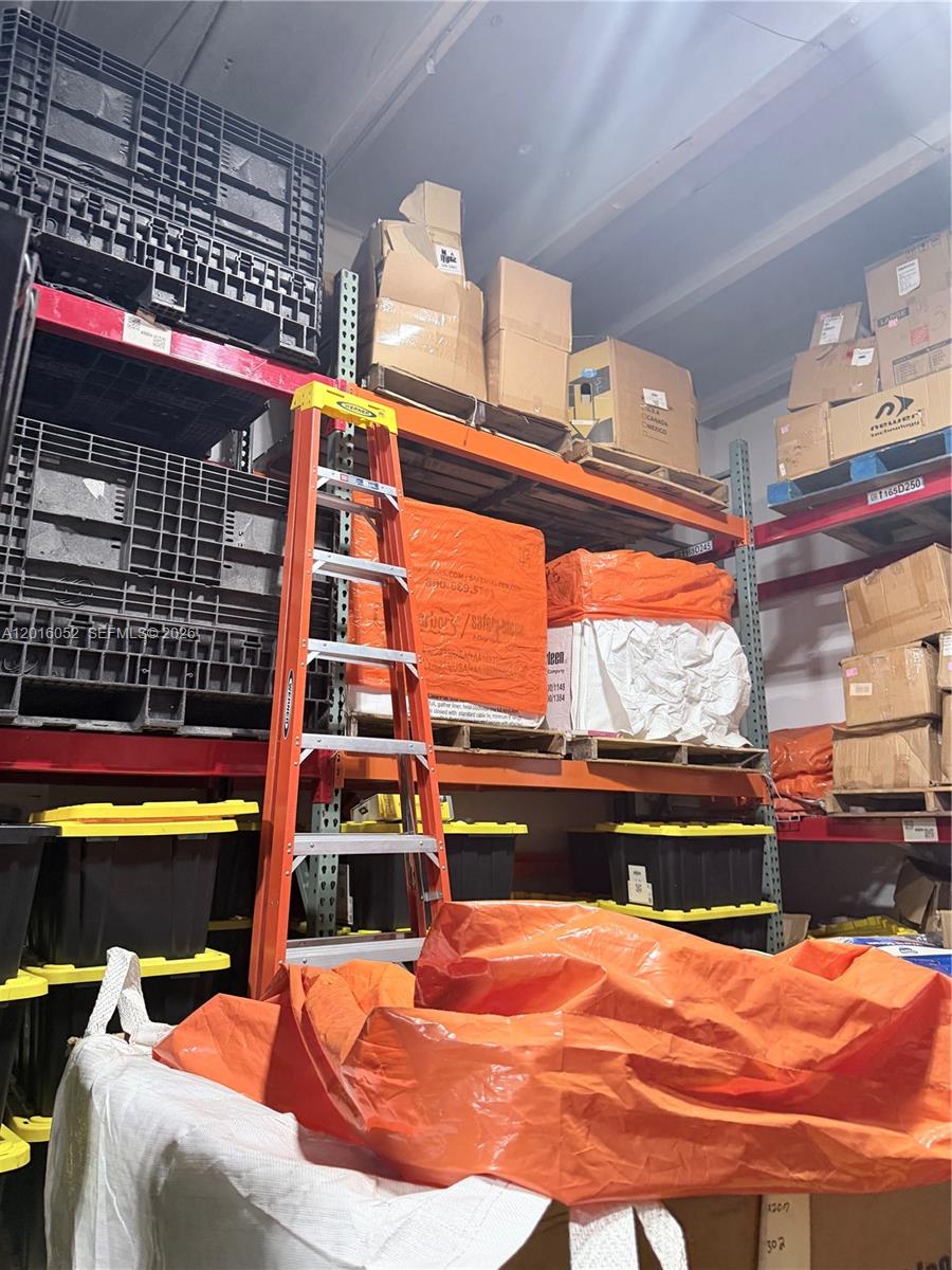 A warehouse storage area features tall metal shelving units filled with boxes, crates, and supplies — 188, Cutler Bay FL 33157, CUTLER BAY, FL