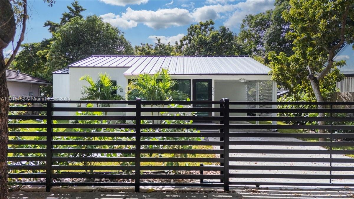 A single-story house with a metal roof and a black horizontal slat fence — 5220 SW 6 ST, Miami FL 33134, MIAMI, FL
